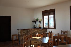 una sala da pranzo con tavoli, sedie e camino di Casa Rural El Nidal a Casas de Don Pedro