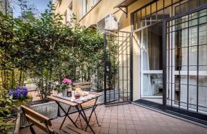 un patio esterno con tavolo, sedie e piante di Portobello Apartments a Bologna