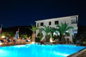 a swimming pool in front of a house at night at Afroditi in Panormos Skopelos