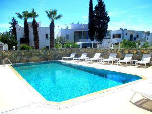 a swimming pool with chairs and a villa in the background at Canna Garden Hotel - Adult Only in Gümbet