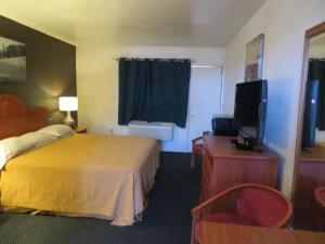 um quarto de hotel com uma cama e uma televisão em Carquinez Inn em Vallejo