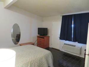 um quarto com uma cama, uma televisão e uma janela em Carquinez Inn em Vallejo