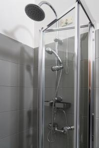 una doccia con una porta in vetro in un bagno di Merulana Star a Roma Altre 53 foto