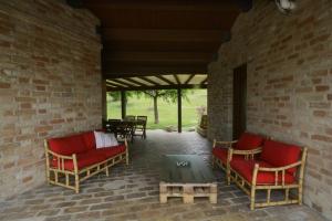 patio z czerwonymi krzesłami i stołem na murze. w obiekcie casa Nenella w mieście Corridonia