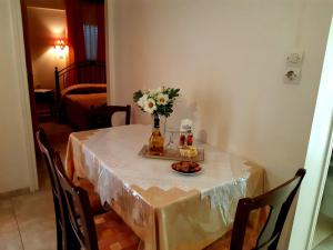 a table with a vase of flowers and a plate of food at Vrokastro Apartments in Istro