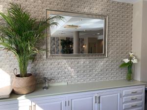 a bathroom with a mirror and a sink at Hotel Arcea Villaviciosa in Villaviciosa