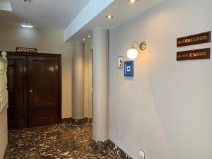 a hallway with a door and a sign on a wall at Hotel Arcea Villaviciosa in Villaviciosa +44 photos