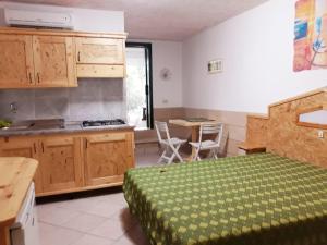 コンカ・スペッキウッラにあるAppartamenti Frassanitoのベッドルーム1室(ベッド1台付)、キッチン(テーブル付)
