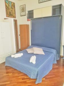 ein blaues Bett mit zwei Handtüchern darüber in der Unterkunft Oly99 in Palermo