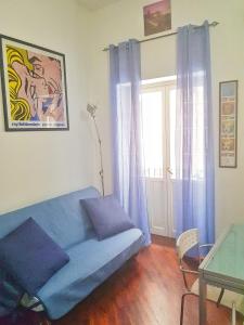 ein Wohnzimmer mit einem blauen Sofa und einem Glastisch in der Unterkunft Oly99 in Palermo