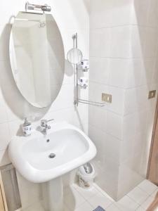 ein weißes Badezimmer mit einem Waschbecken und einem Spiegel in der Unterkunft Oly99 in Palermo