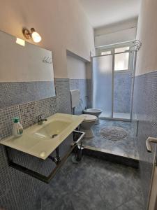 a bathroom with a sink and a toilet and a mirror at Rooms for rent 67 in Sassari