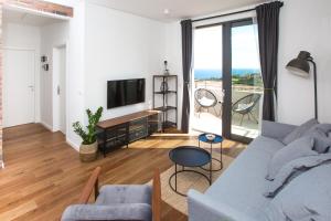 een woonkamer met een bank en een tv bij DuArt Cozy Apartment in Dubrovnik