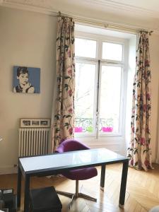 een woonkamer met een tafel en een raam bij Parc Monceau in Parijs