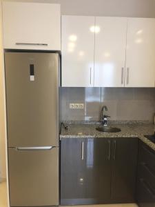 a kitchen with a refrigerator and a sink at Belle Vue Apartment in Batumi