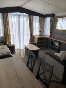 a living room with a couch and a table at Par Sands Coastal Holiday park in Par