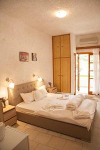 sypialnia z dużym łóżkiem i oknem w obiekcie Gioma Hotel w mieście Agia Galini