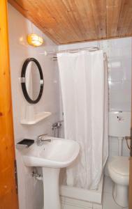 a bathroom with a sink and a shower curtain at Gioma Hotel in Agia Galini