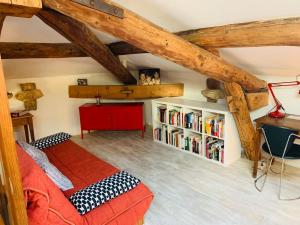 - une chambre avec un lit et une étagère avec des livres dans l'établissement Maison de maitre, coeur de ville., à Sète