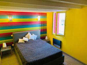 - une chambre colorée avec un lit et un mur coloré dans l'établissement Maison de maitre, coeur de ville., à Sète