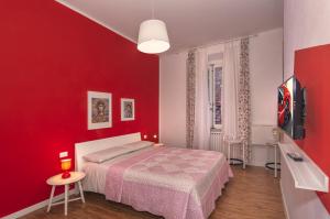 a red bedroom with a bed and a tv at Affittacamere del Centro in Lucca