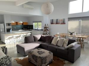 a living room with a couch and a kitchen at Damais - 4 king or 8 single beds WiFi, Netflix, Alexa, pet friendly in Daylesford