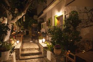 an outdoor patio with tables and potted plants at night at Gioma Hotel in Agia Galini