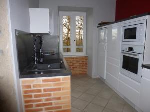 a kitchen with a sink and white appliances at saint trome in Espinas