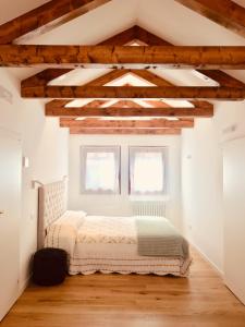 a bedroom with a bed in a room with wooden ceilings at Bianca Cappello House in Venice