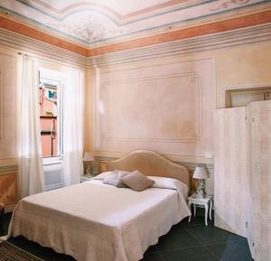 a bedroom with a white bed in a room with a window at Uliveto Saglietto Agriturismo a Poggi Apartments in Imperia