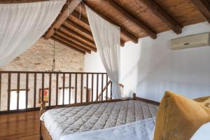 a bedroom with a bed in a room with wooden ceilings at Villa Margarita in Anafonítria