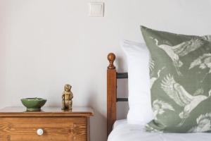 a bed with a green and white pillow and a wooden night stand at Villa Margarita in Anafonítria