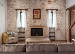 a living room with a couch and a fireplace at Villa Margarita in Anafonítria