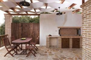 a patio with a table and chairs and a fireplace at Villa Margarita in Anafonítria