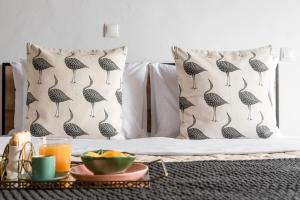 a bed with black and white pillows and a tray of fruit at Villa Margarita in Anafonítria