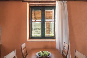 a table with a bowl of fruit in front of a window at Villa Margarita in Anafonítria
