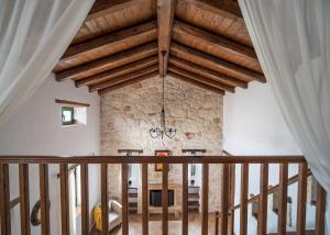 a dining room with a stone wall and wooden ceilings at Villa Margarita in Anafonítria