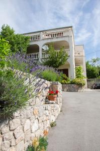 una pared de piedra con flores frente a una casa en SEA VIEW apartments en Klenovica