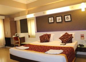 a hotel room with a large bed in a room at Hotel Pooja International in Dāvangere