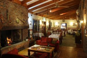 a restaurant with a fireplace and tables and chairs at Copper Country Motor Inn in Nanango