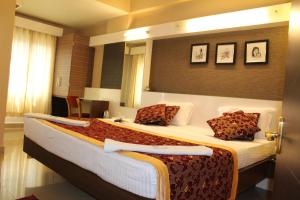 a bedroom with a large bed in a room at Hotel Pooja International in Dāvangere
