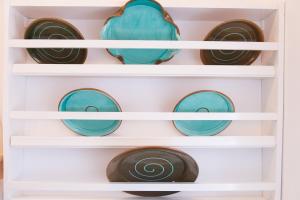 a cupboard filled with blue and green plates at Houses at Chrisopigi Sifnos in Chrisopigi