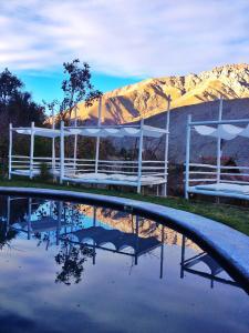 una piscina de agua frente a una montaña en Cabañas Elquimista, en Pisco Elqui