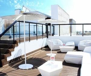 a balcony with white furniture and an umbrella at Aruma Hotel Boutique in Arica