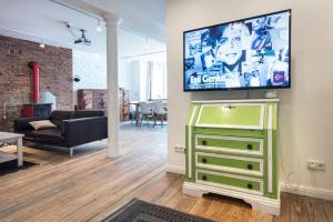 a living room with a television on top of a dresser at FeWo Parkblick HH Schanze in Hamburg