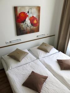 ein Bett mit zwei Kissen und einem Gemälde an der Wand in der Unterkunft KIBI Rooms self check-in in Wien