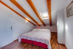 a bedroom with a bed in a room with wooden ceilings at apartman Nataša in Mali Lošinj