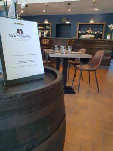 un cartel en un restaurante con mesa y sillas en Au Wingenerhof, en Wingen-sur-Moder