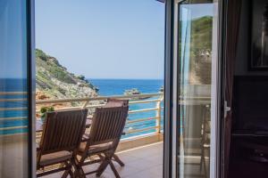 a balcony with two chairs looking out at the ocean at Luxury Seaside House in Mades Heraklion in Agia Pelagia