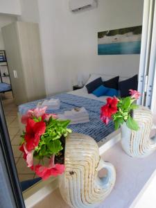 una habitación con dos jarrones con flores en un mostrador en B&B Vento del Mare, en San Pietro in Bevagna